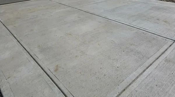 Crew finishing a crowned concrete driveway on a rural Hartselle, AL lot